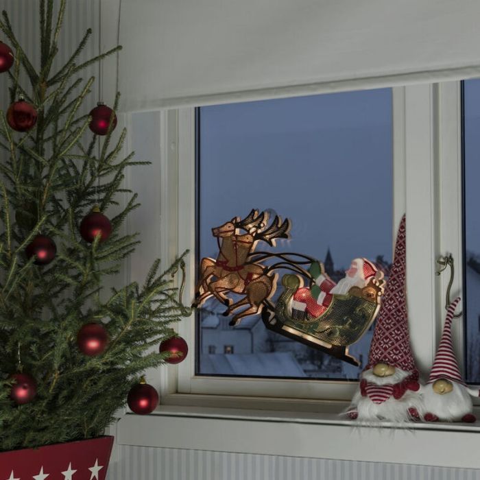 Weihnachtsmann mit Rentier- und Schlittenfenstersilhouette